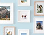 Various photo prints framed and hanging on a blue wall